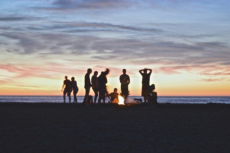 Group of friends having fun at a beach bonfire.