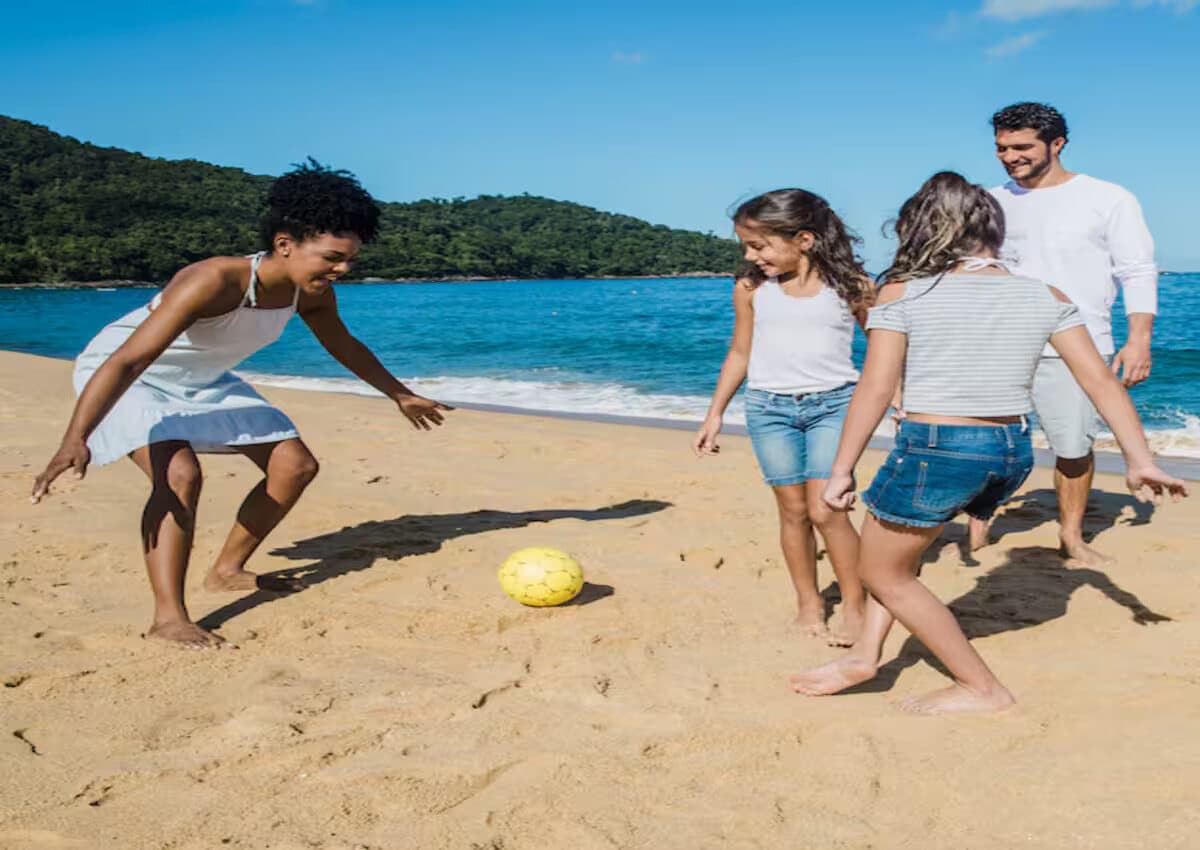 Parents having fun playing with their children at the beach