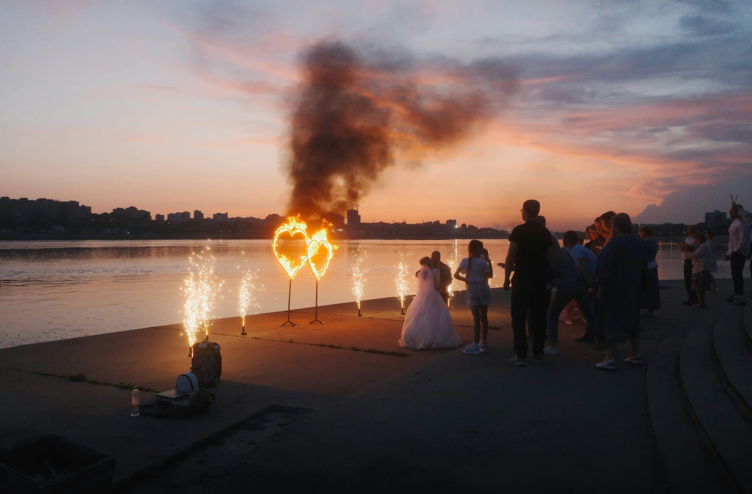 A wedding couple watches burning heart displays