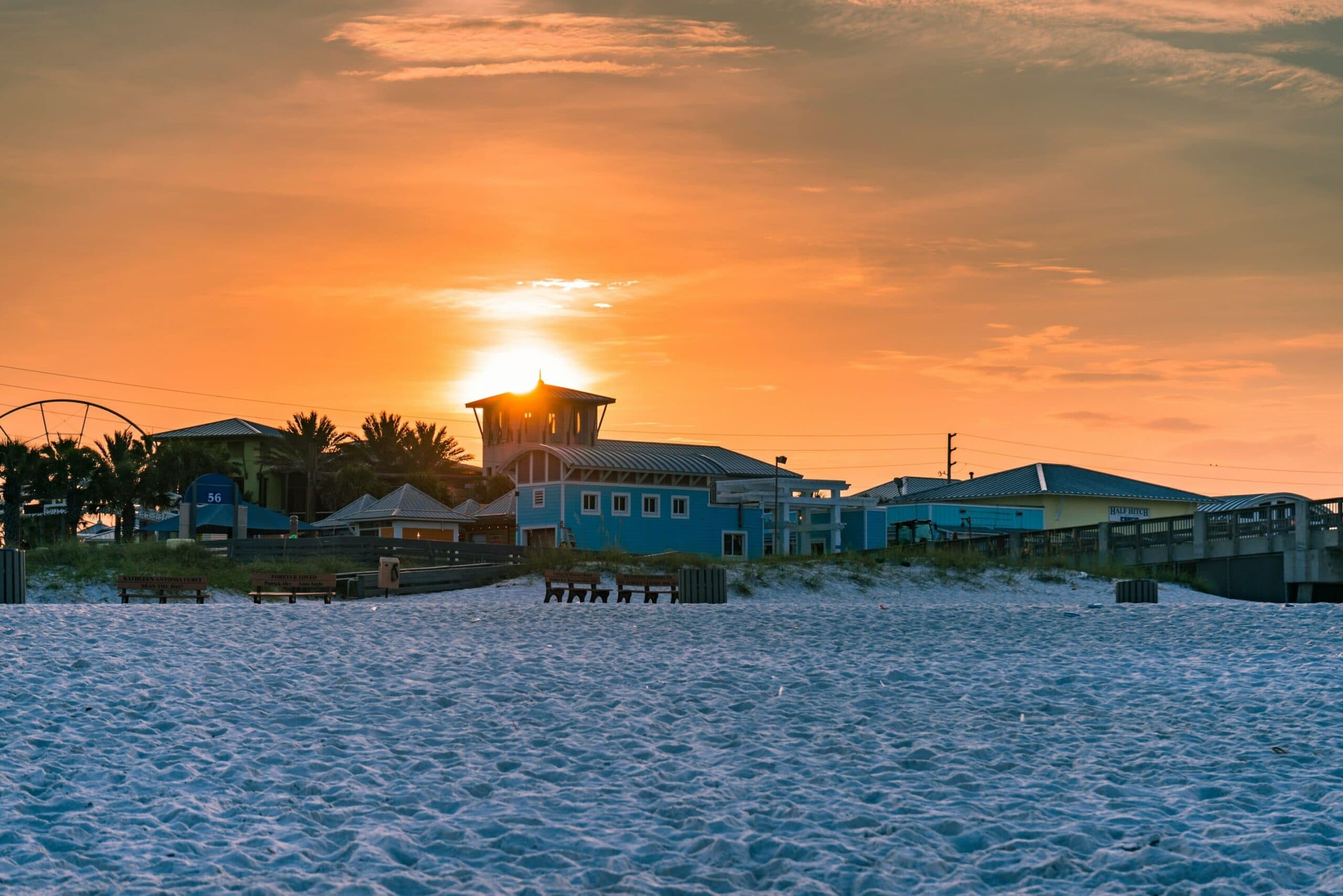 Sunset glows behind beach buildings